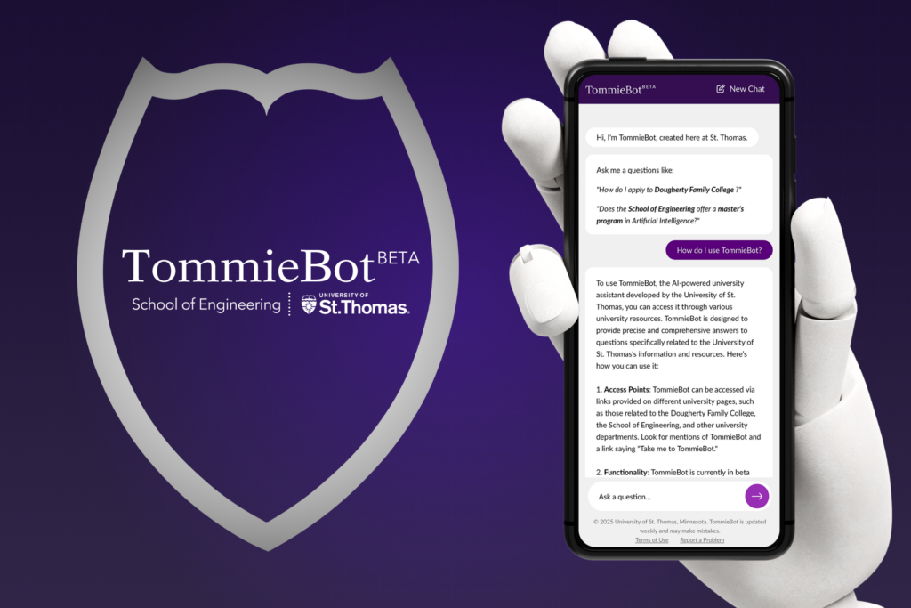 Image of a robot hand holding a smartphone that is displaying the TommieBot chat feature.